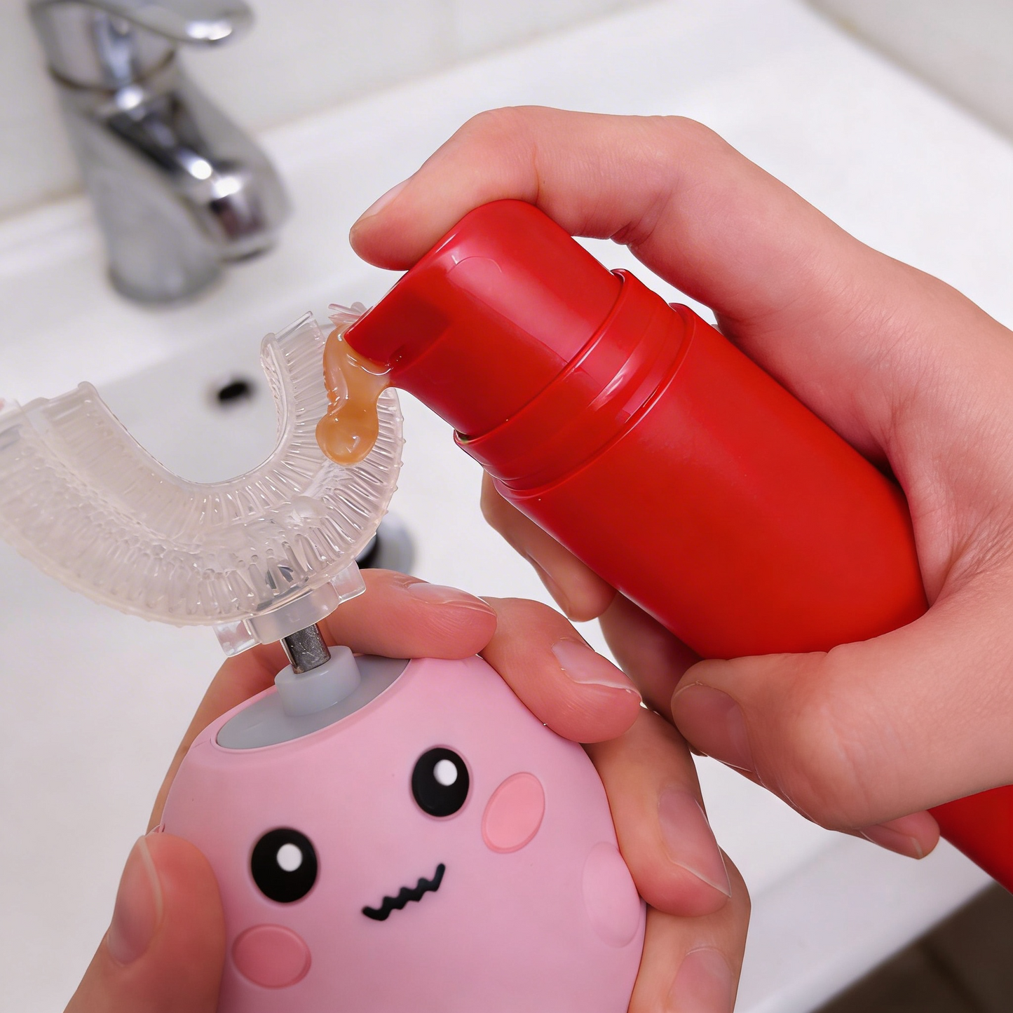 child squeezing toothpaste onto pink kids toothbrush