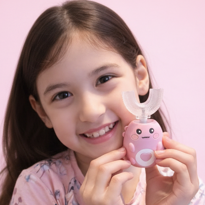 Young girl holding a pink Danny the Dinosaur U Shaped Electric Toothbrush against a pink background